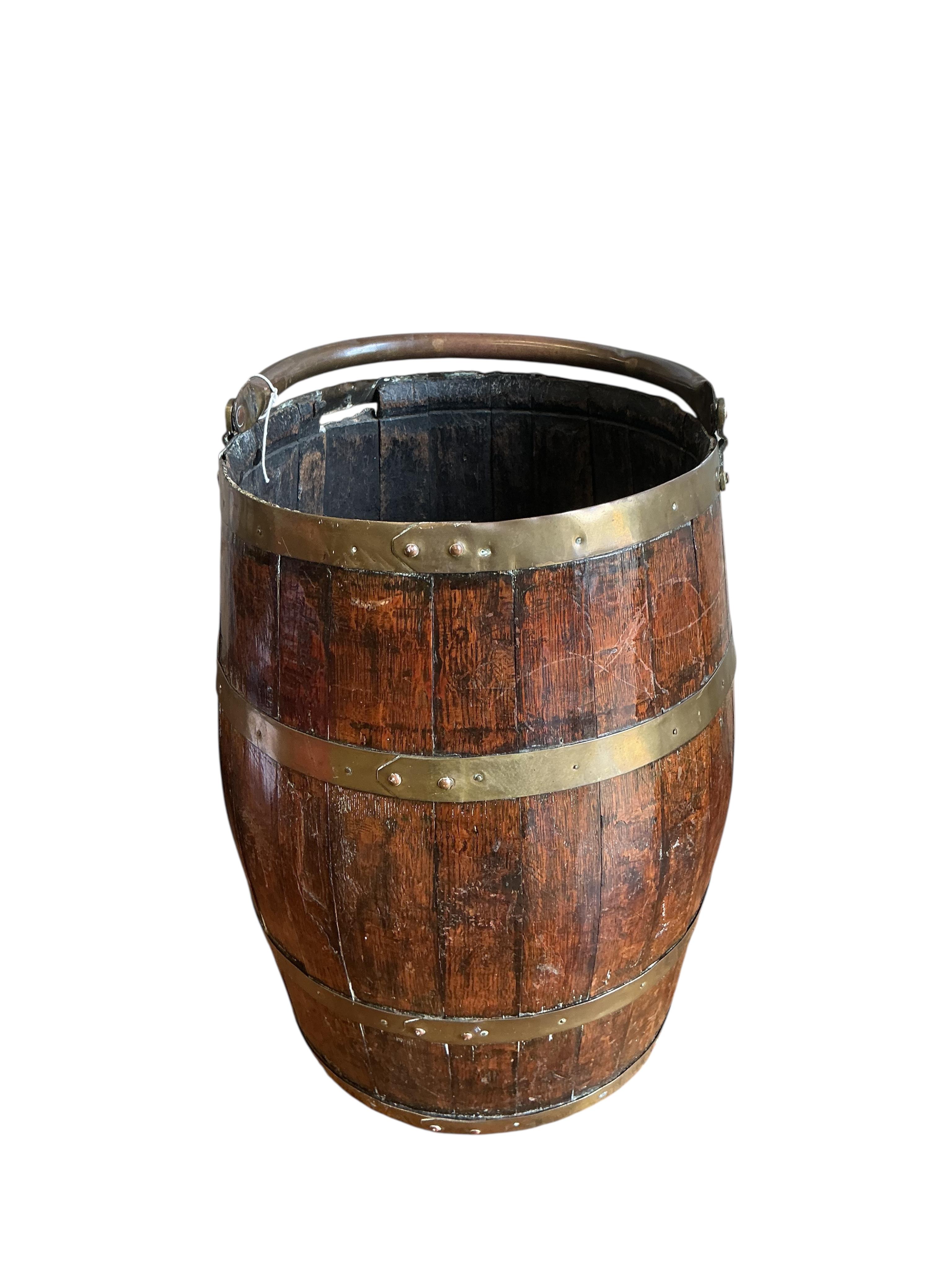 A brass bound coopered oak barrel with swing handle, height 48cm